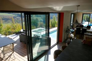 a living room with a view of a house with a balcony at Villa d'architecte avec vue imprenable in Cobonne