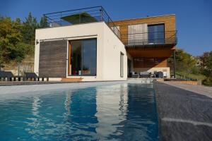 a house with a swimming pool in front of a house at Villa d'architecte avec vue imprenable in Cobonne