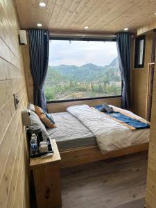 a bed in a room with a large window at Mây Đá Homestay in Loung Co +55 photos