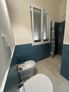 a bathroom with a white toilet and a sink at Le Muciare in Favignana +9 photos