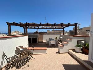 a patio with a table and chairs on a roof at Le Muciare in Favignana
