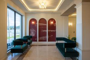 a waiting room with green chairs and a wall of windows at Hotel Apolodor in Orşova