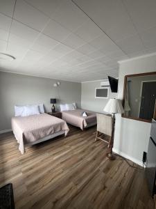 a bedroom with two beds and a lamp in it at Gateway Motel USA in Madawaska
