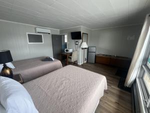 a hotel room with two beds and a desk at Gateway Motel USA in Madawaska +5 photos