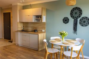 a kitchen and dining room with a table and chairs at Przystanek Babia Apartamenty in Lipnica Wielka