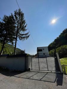 a gate in a parking lot with a tree at Forest View Villa in Ilijaš
