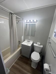 a small bathroom with a toilet and a sink at Gateway Motel USA in Madawaska