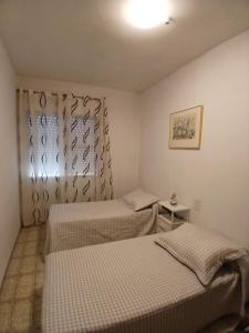 two beds in a small room with a window at Lo Racó del Delta in Sant Jaume d'Enveja