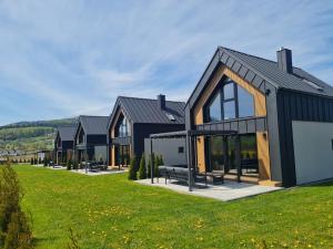 a house with a black roof and windows at Panorama Sudety in Nowa Bystrzyca