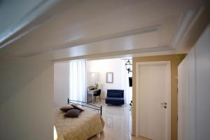 a bedroom with a bed and a blue chair at KAPSOTT B&B in Bisceglie