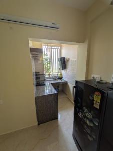 a kitchen with a black refrigerator and a counter at Shree's Seaside Homestay - Sea Pearl in Magdāl +9 photos
