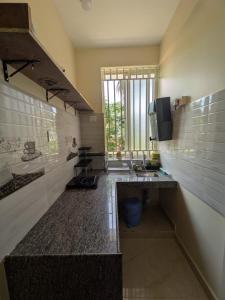 a bathroom with a sink and a television in it at Shree's Seaside Homestay - Sea Pearl in Magdāl
