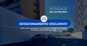 a sign for a building with cars parked in a parking lot at Hotel Dan Inn Barretos by Nacional Inn in Barretos