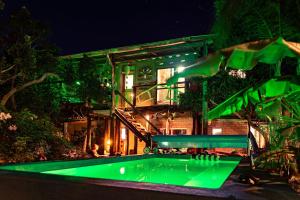 a house with a green swimming pool at night at Lo De Ro in Barra de Valizas