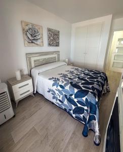 a bedroom with a bed with a blue and white comforter at Espacio I in Cullera +21 photos