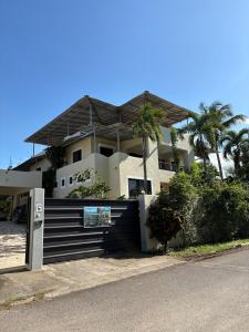 a white house with palm trees in front of it at CASA Angelo in Sosúa