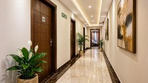 a corridor in a hotel with potted plants at Hotel Kian by JMD Group in New Delhi