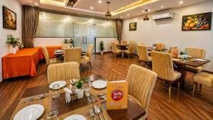 a restaurant with a dining room with tables and chairs at Hotel Kian by JMD Group in New Delhi