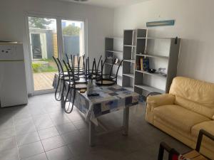 a living room with a table and a couch at hirondelle 1 in Noirmoutier-en-l'lle +12 photos