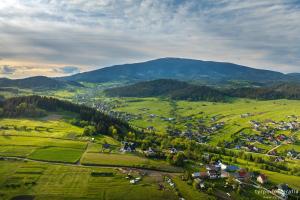 an aerial view of a village in a green field at Przystanek Babia Apartamenty in Lipnica Wielka