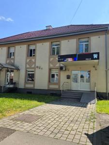 a building with a sign in front of it at Apartman Wegele in Teslić