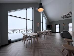 a room with tables and chairs and large windows at Gudelių Kempingas Camp in Gudeliai +18 photos