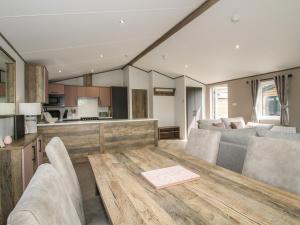 a kitchen and living room with a wooden table at Peony in Leominster +27 photos