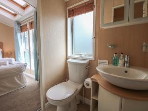 a bathroom with a white toilet and a sink at Daisy in Leominster