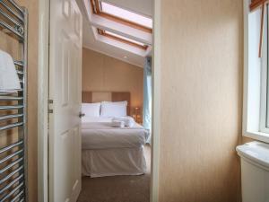 a bedroom with a bed with a white bedspread and a window at Daisy in Leominster +11 photos