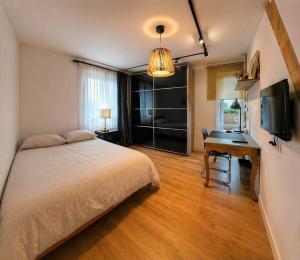a bedroom with a bed and a desk and a television at Les Rives Rémoises in Reims