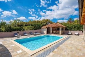 a swimming pool with chairs and a gazebo at Lux pool Villa Zen - located in peaceful village near Rijeka and Opatija in Klana +29 photos