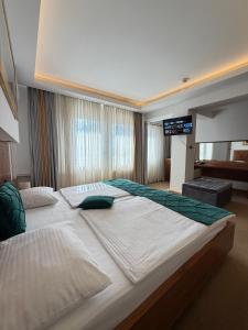 a large bedroom with two beds and a flat screen tv at Hotel Exclusive in Sarajevo