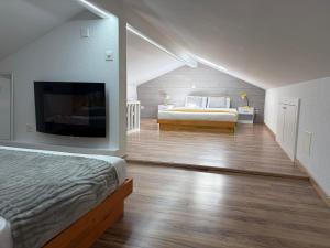 a bedroom with a bed and a flat screen tv at Chalet panoramique avec vue alpine à 180 degrés - poêle scandinave & nature in Grône