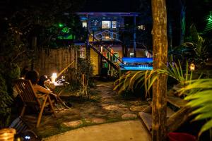 a couple sitting at a table in a garden at night at Lo De Ro in Barra de Valizas