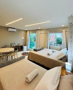 two beds in a room with a table and a dining room at Blessed House Atins in Atins