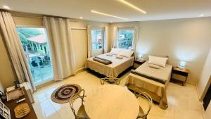 a bedroom with two beds and a table and chairs at Blessed House Atins in Atins