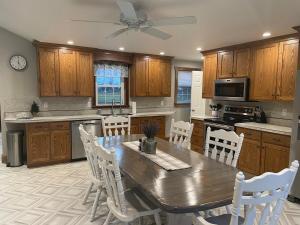 a kitchen with a wooden table and white chairs at Restored 1800s Farmhouse on Working Sheep Farm in Bird-in-Hand