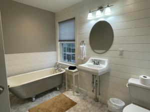a bathroom with a tub and a sink and a bath tub at Restored 1800s Farmhouse on Working Sheep Farm in Bird-in-Hand +48 photos