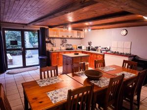 a kitchen with a wooden table with chairs and a tableasteryasteryasteryasteryastery at Reefteach Lodge in Sodwana Bay