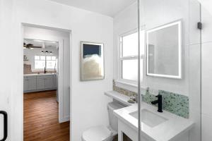 a white bathroom with a sink and a mirror at Steps to the pier! in San Clemente +23 photos