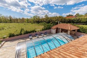 a swimming pool with two chairs and a house at Lux pool Villa Zen - located in peaceful village near Rijeka and Opatija in Klana