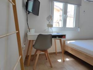 a bedroom with a desk with a chair and a bed at Little Kristi in Palaiókastron