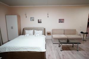 a bedroom with a bed and a couch and a table at Apartments Valentinaa in Gevgelija