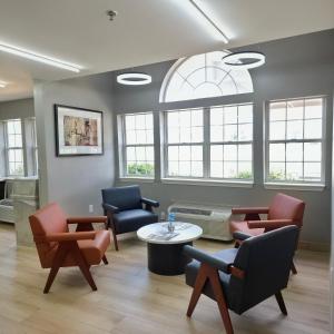 a waiting room with chairs and a table and windows at Microtel Inn & Suites Claremore Route 66 in Claremore