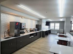 a large kitchen with black cabinets and white counter tops at Microtel Inn & Suites Claremore Route 66 in Claremore