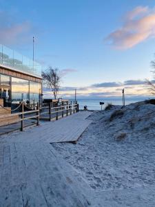 a boardwalk on the beach next to a building at Granat's Gästehouse in Höllviken