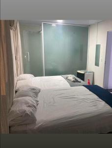 a bedroom with two beds and a blue wall at Donwtonw in Arraial do Cabo +7 photos