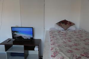 a bedroom with a bed and a desk with a laptop at Donwtonw in Arraial do Cabo
