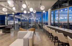 a restaurant with chairs and a bar with windows at Luxury Apartments with View & Indoor Heated Pool in Montreal +147 photos