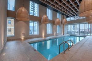 a large swimming pool in a building with windows at Luxury Apartments with View & Indoor Heated Pool in Montreal